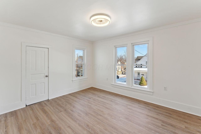 spare room with crown molding and light hardwood / wood-style floors