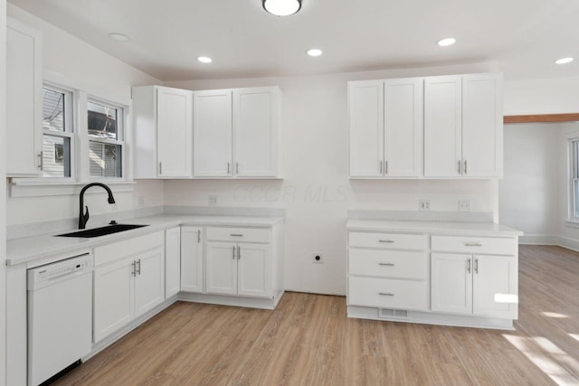 kitchen with dishwasher, sink, light hardwood / wood-style flooring, and white cabinets