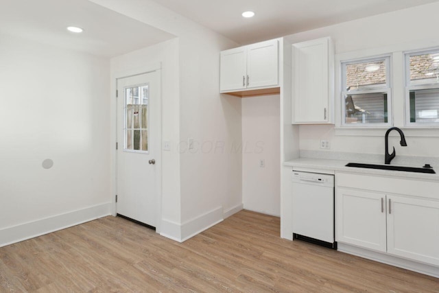 kitchen featuring dishwasher, sink, white cabinets, and light wood-type flooring