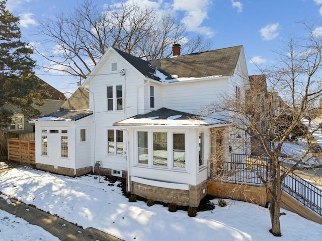 view of snow covered rear of property