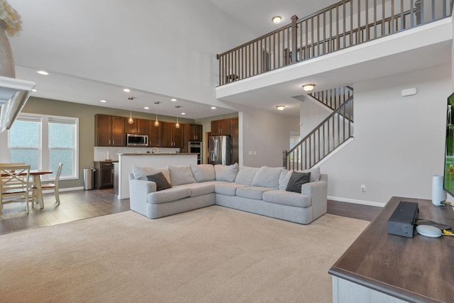 carpeted living room with a towering ceiling