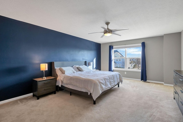 carpeted bedroom featuring a textured ceiling and ceiling fan