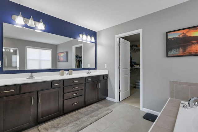 bathroom with tile patterned flooring, vanity, and a washtub