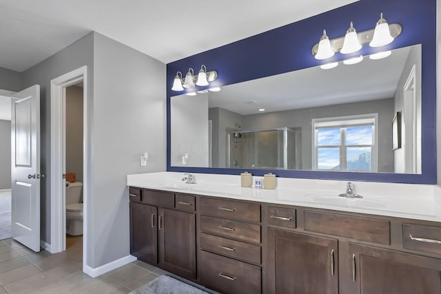 bathroom with vanity, a shower with shower door, tile patterned floors, and toilet