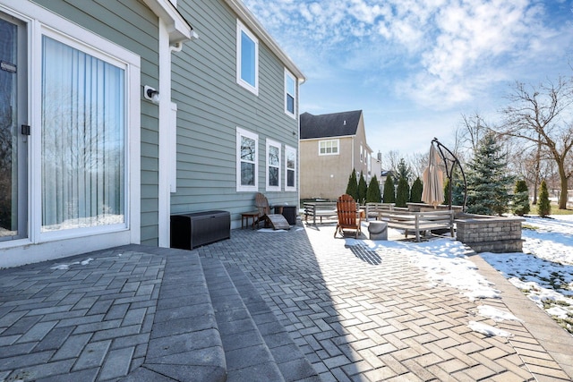 snow covered patio featuring a fire pit