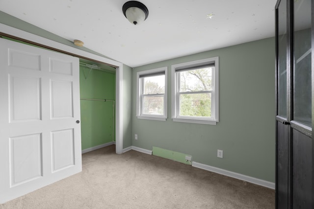 unfurnished bedroom featuring carpet, a closet, and baseboards