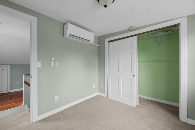 unfurnished bedroom featuring baseboards, carpet flooring, a closet, and a wall mounted AC
