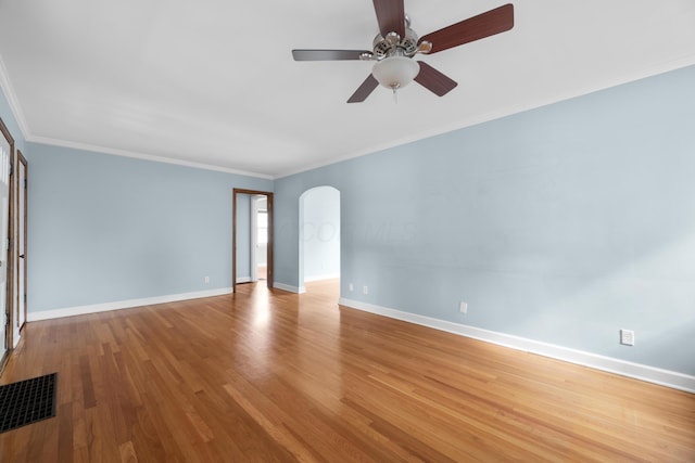 empty room with ceiling fan, arched walkways, baseboards, and visible vents