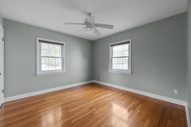empty room with light wood finished floors, baseboards, and ceiling fan