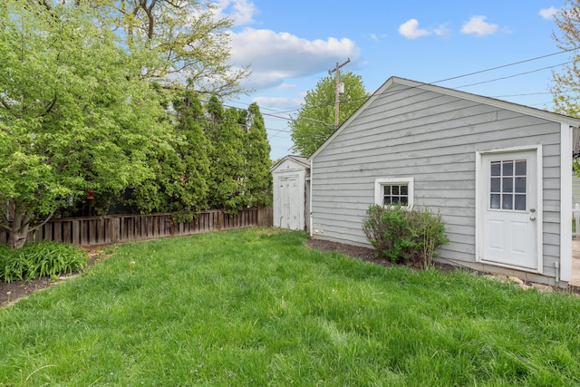 view of yard featuring an outbuilding, fence, and a storage unit