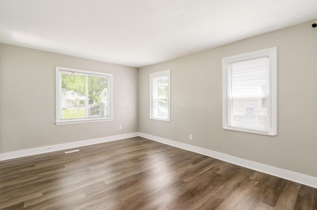 empty room with dark hardwood / wood-style flooring