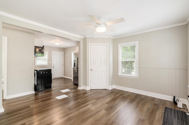 unfurnished living room featuring crown molding, dark hardwood / wood-style floors, and ceiling fan