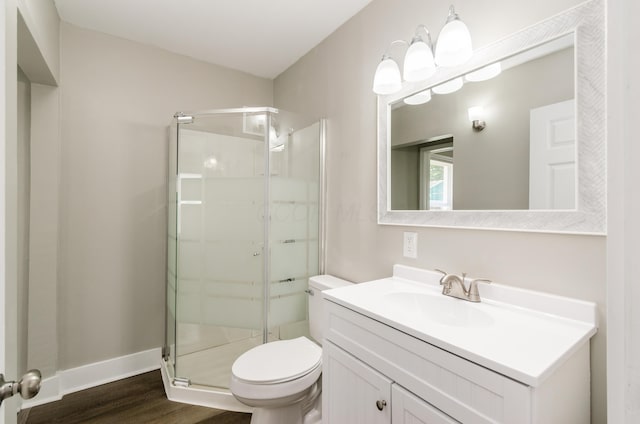 bathroom featuring an enclosed shower, vanity, wood-type flooring, and toilet