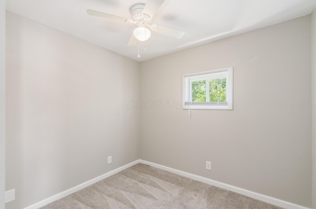 carpeted spare room with ceiling fan