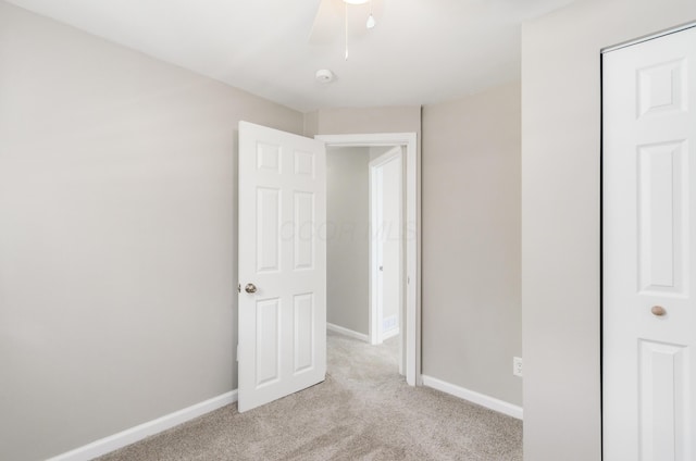 unfurnished bedroom with light colored carpet and ceiling fan