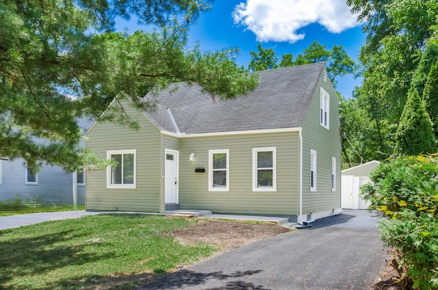 new england style home with a storage unit and a front yard