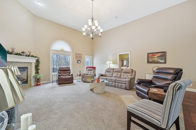 carpeted living room featuring a towering ceiling and a chandelier