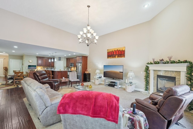 living room featuring a towering ceiling, a fireplace, and a notable chandelier