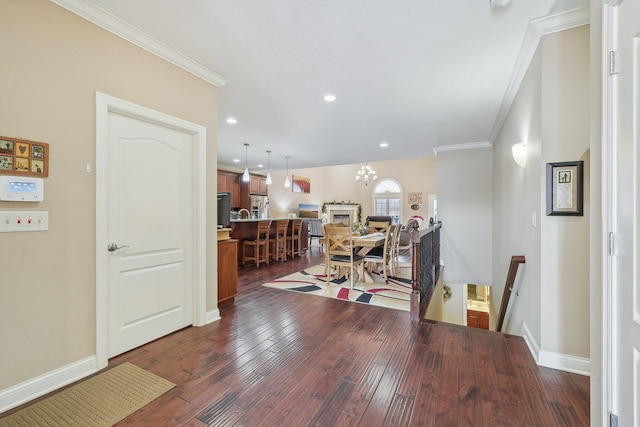 interior space featuring dark wood-type flooring, crown molding, and an inviting chandelier