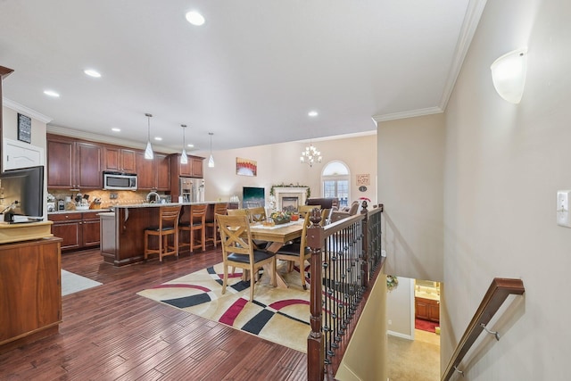 dining room featuring ornamental molding, dark wood-type flooring, and an inviting chandelier