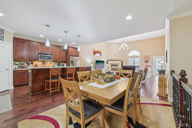 dining space featuring an inviting chandelier, ornamental molding, and dark hardwood / wood-style floors