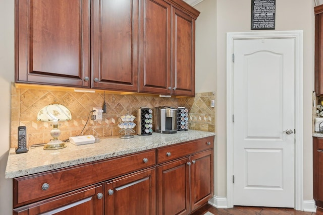 kitchen with light stone countertops, hardwood / wood-style floors, and decorative backsplash