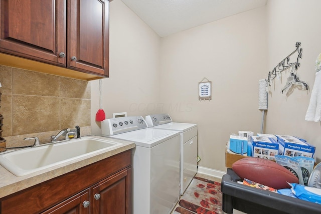 laundry room featuring cabinets, separate washer and dryer, and sink