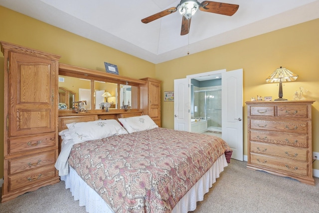 bedroom with lofted ceiling, light carpet, and ensuite bath