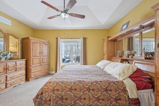 carpeted bedroom featuring lofted ceiling, a tray ceiling, and ceiling fan