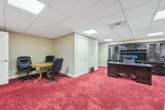 carpeted office space with a paneled ceiling