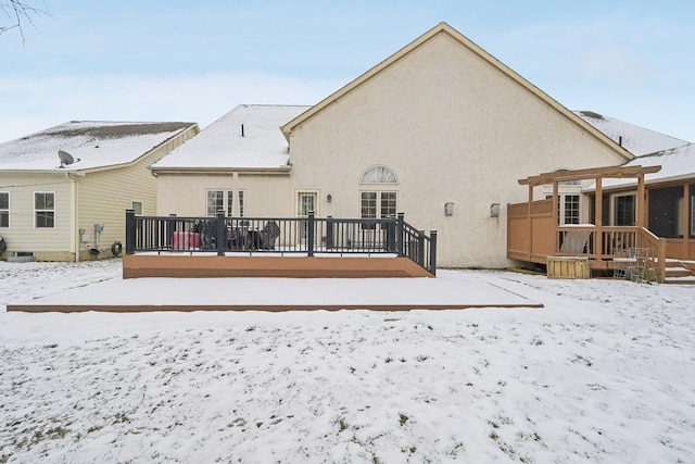 snow covered house featuring a deck