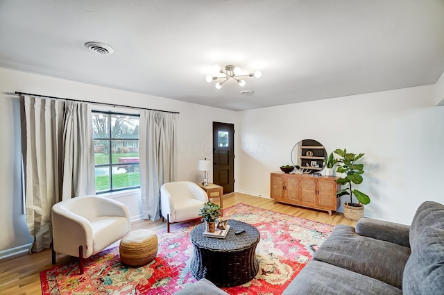 living room featuring an inviting chandelier and light hardwood / wood-style flooring