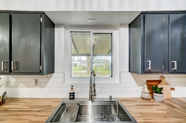 kitchen with wood counters, sink, and tasteful backsplash