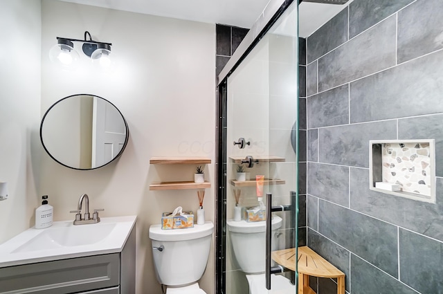 bathroom with a shower with door, vanity, and toilet