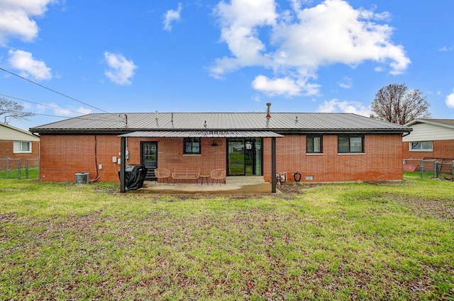 rear view of property with a patio and a yard