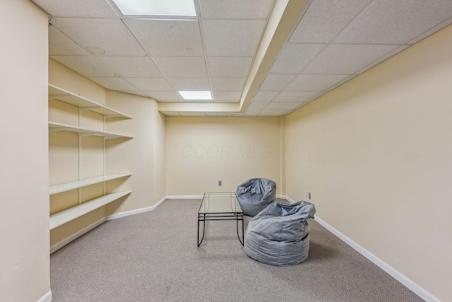 living area with carpet floors and a paneled ceiling