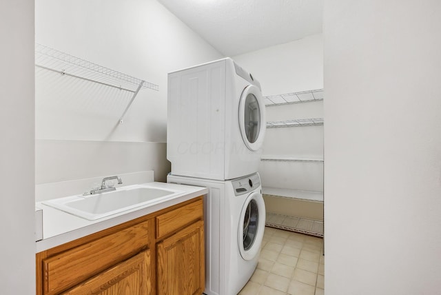 laundry room featuring sink and stacked washer and clothes dryer