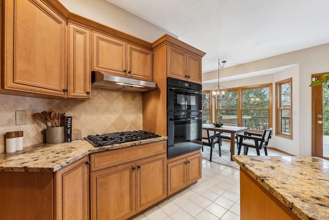 kitchen featuring stainless steel gas cooktop, tasteful backsplash, pendant lighting, black double oven, and light stone countertops