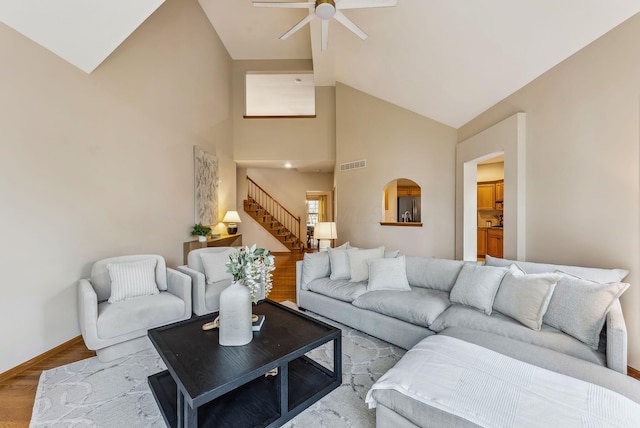 living room featuring hardwood / wood-style flooring, ceiling fan, and high vaulted ceiling