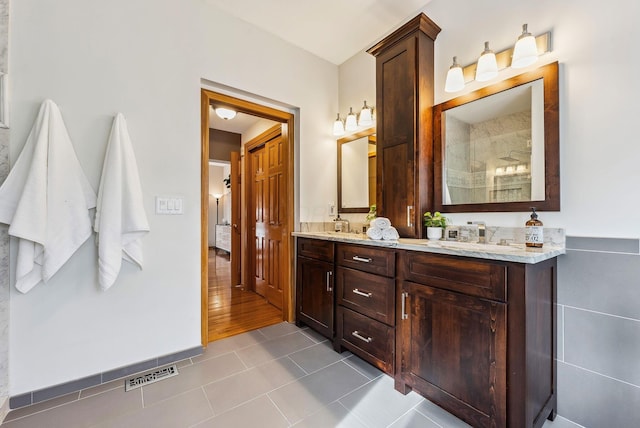 bathroom with walk in shower, tile patterned floors, and vanity