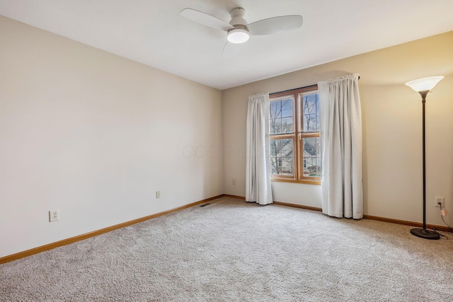 unfurnished room with ceiling fan and carpet