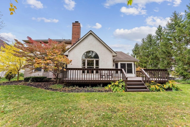 rear view of property with a yard and a deck