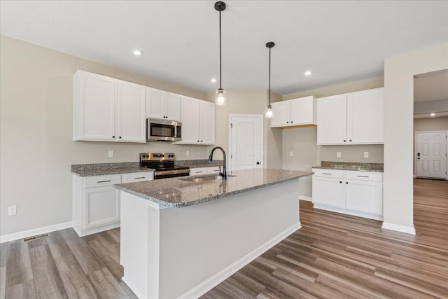 1233 Heathgate Way, Fairborn, OH 45324 - kitchen featuring appliances with stainless steel finishes, wood finished floors, white cabinetry, dark stone counters, and recessed lighting