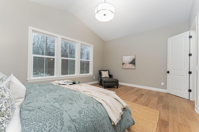 bedroom with light hardwood / wood-style flooring, multiple windows, and vaulted ceiling