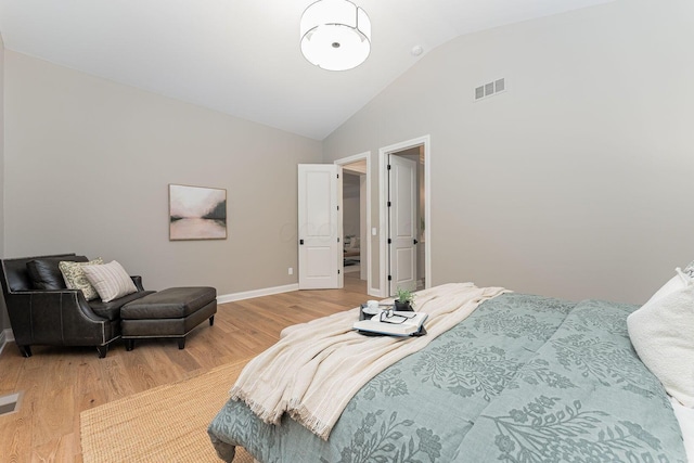 bedroom with hardwood / wood-style floors and high vaulted ceiling