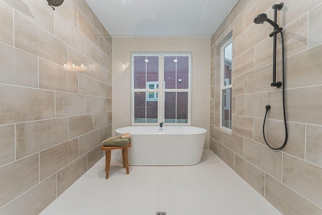 bathroom featuring plus walk in shower, tile patterned flooring, and tile walls