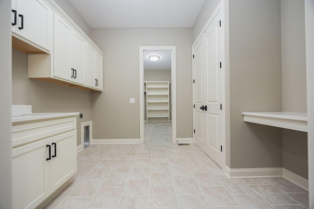 washroom with cabinets, light tile patterned floors, and electric dryer hookup