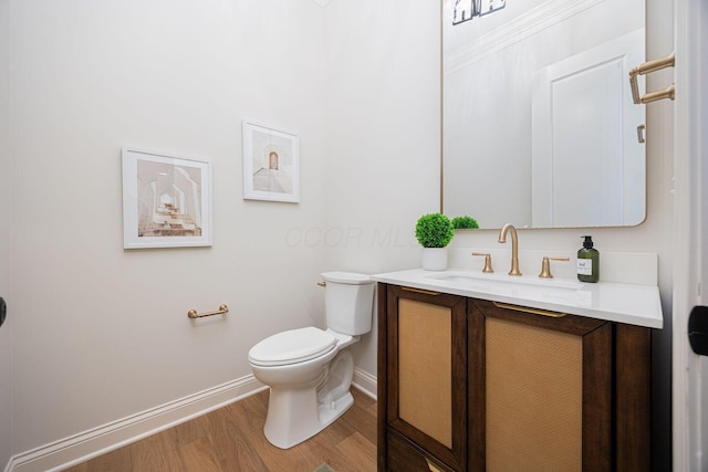 bathroom featuring wood-type flooring, toilet, and vanity