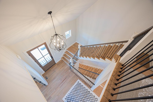 stairway with hardwood / wood-style flooring and a chandelier