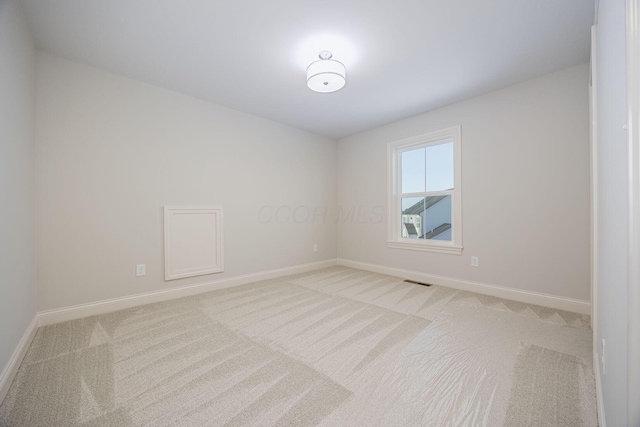 spare room featuring light colored carpet